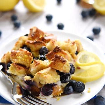 Lemon Blueberry Overnight Baked French Toast with Lemon Syrup on white plate.