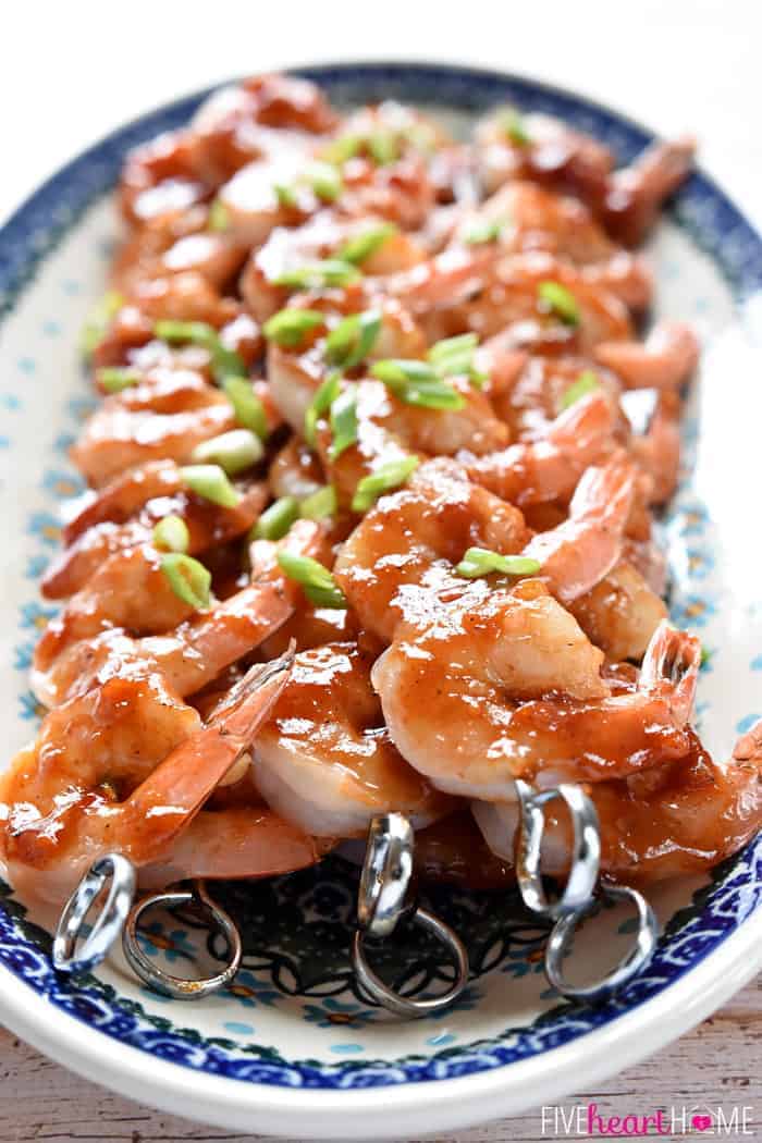 Skewers of Honey Garlic Shrimp on a blue and white oval platter