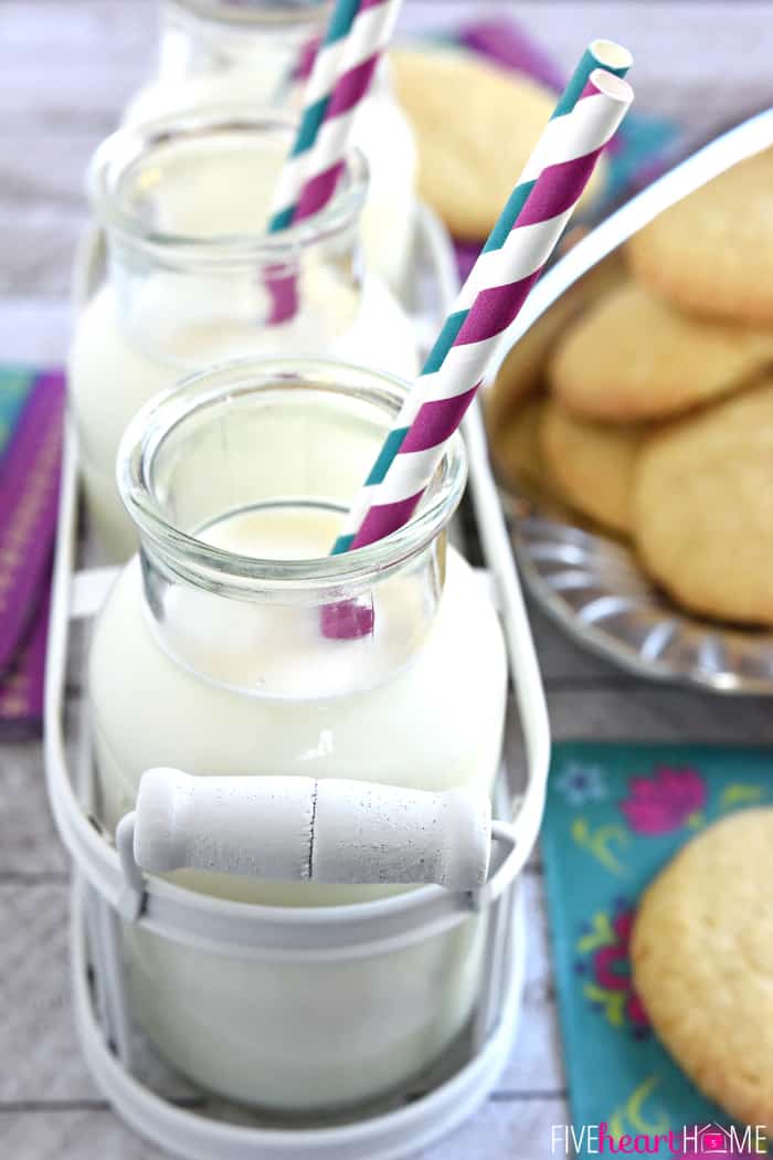 Soft Sugar Cookies ~ easy to make because they require NO ROLLING! They're tender and puffy with a crunchy coating of sugar and loads of vanilla flavor! | FiveHeartHome.com Row of 3 jars of milk with paper straws.