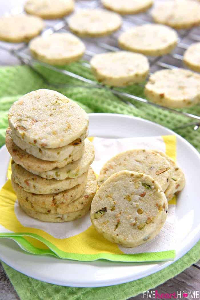 Pistachio Shortbread Cookies Piled on a White Plate with Decorative Napkins