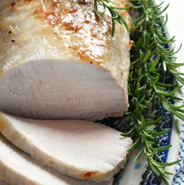 Rosemary Cider Brined Pork Loin on platter with rosemary.