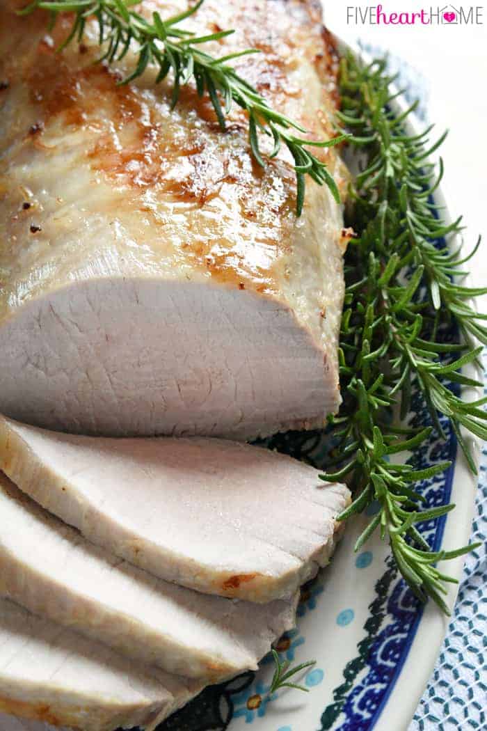 Rosemary Cider Brined Pork Loin on platter with rosemary.