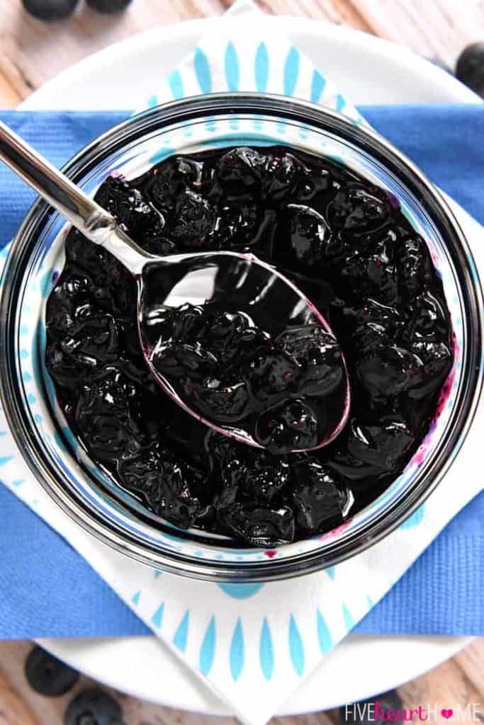 Aerial view of spoonful of Blueberry Compote over bowl.