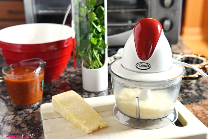 Various Ingredients from Parmesan to Parsley to Marinara with a Red Bowl and Food Processor to Grate Cheese 