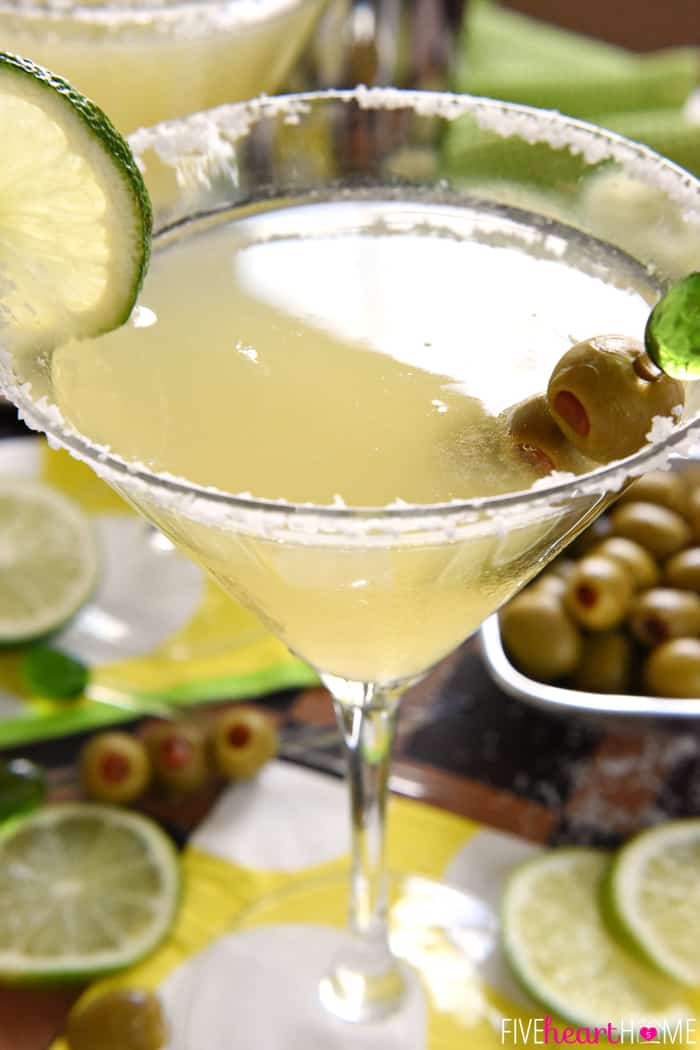 Mexican Martini with a garnish of lime plus olives on decorative pick.