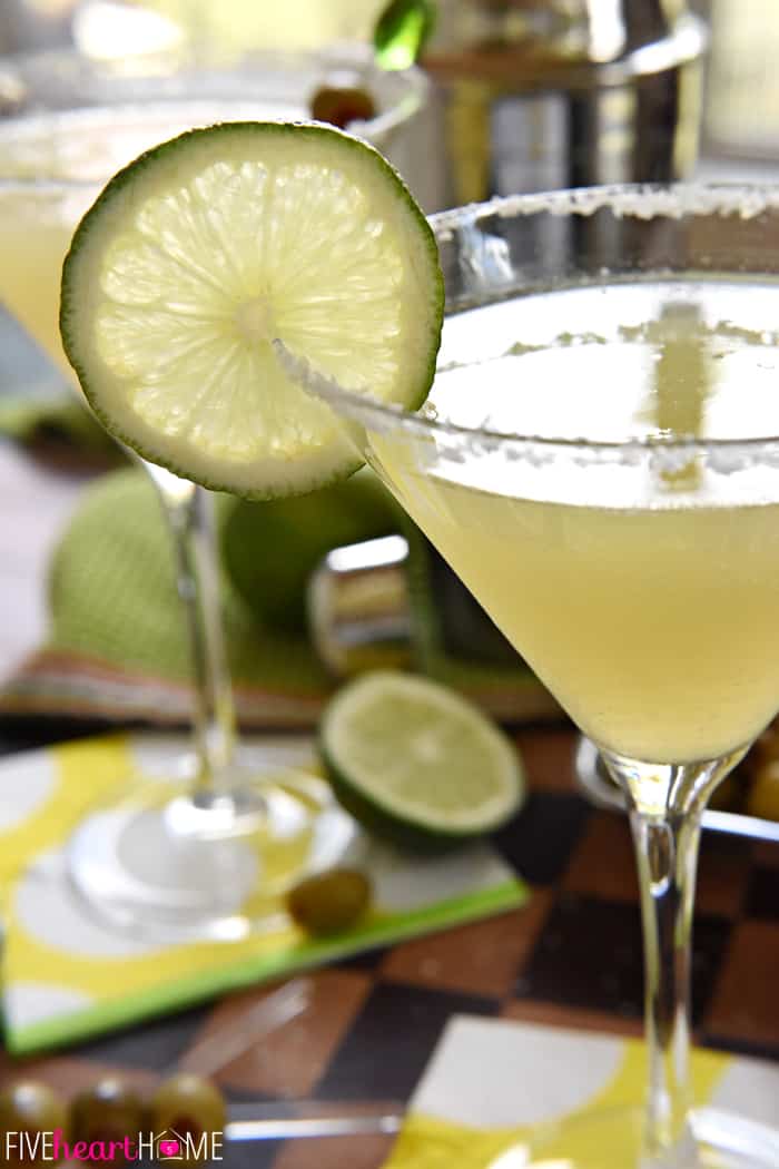 Side view of Mexican Martini in glass garnished with salt and a slice of lime.