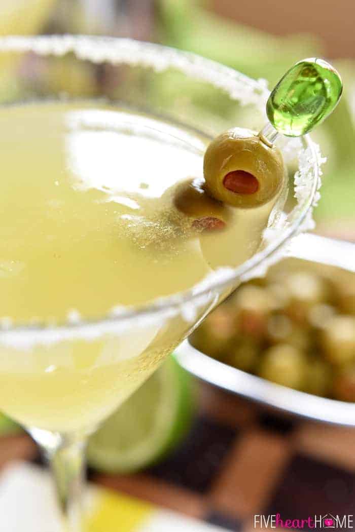 Close-up of olives at edge of salt-rimmed Mexican Martini glass.