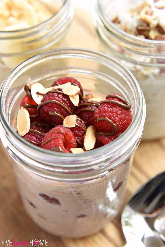 Overnight Oats recipe topped with raspberries, almonds, and Nutella.