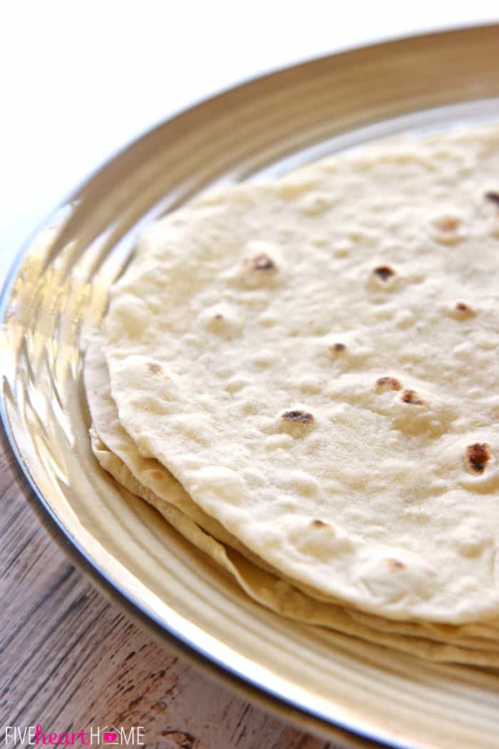 Stack of flour tortillas on a plate.