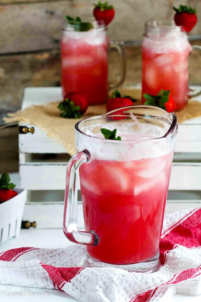 Strawberry Punch in a pitcher with glasses in background