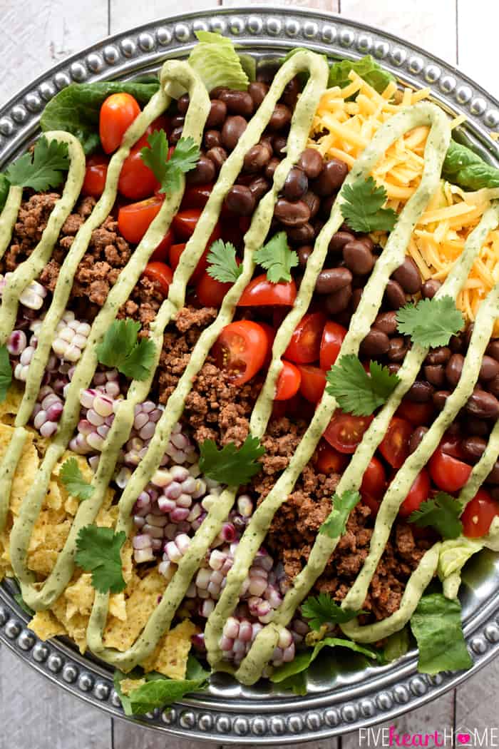 Ultimate Taco Salad ~ an explosion of contrasting flavors and textures, from spicy taco meat and velvety black beans to acidic tomatoes and crisp fresh corn, all topped with crunchy tortilla chips and a creamy, cilantro-flecked Avocado Ranch Dressing! | FiveHeartHome.com