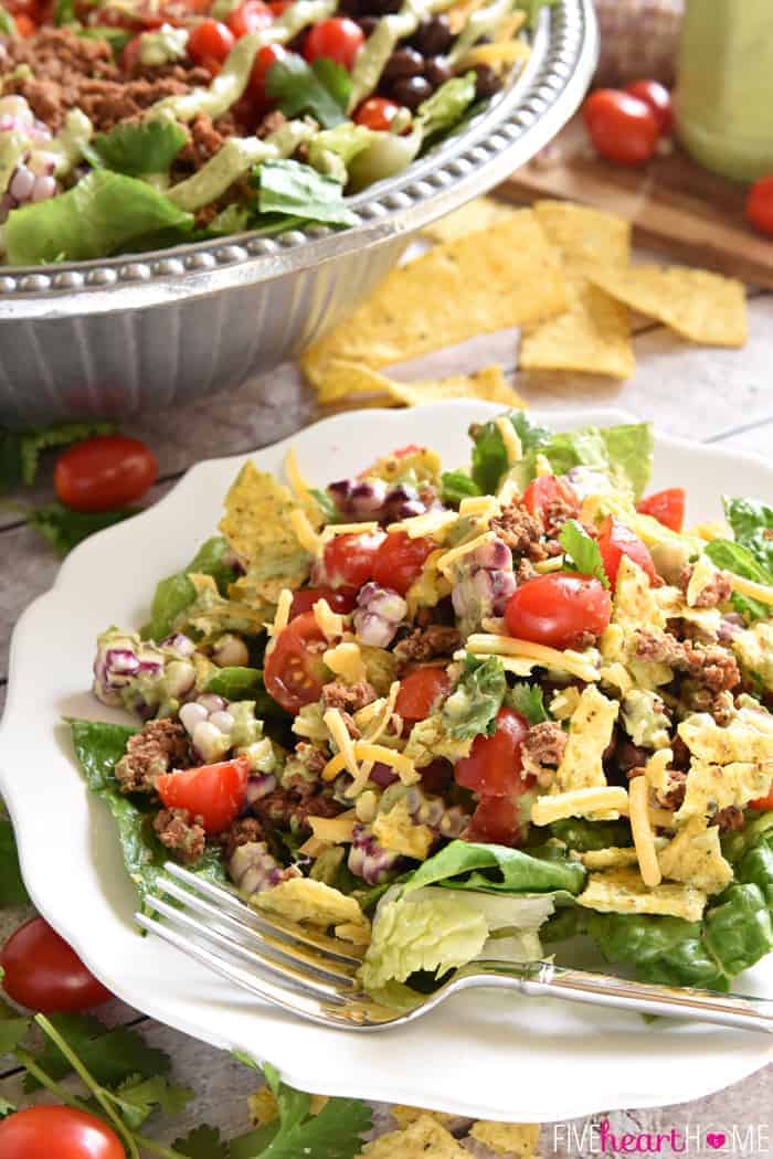 Ultimate Taco Salad ~ an explosion of contrasting flavors and textures, from spicy taco meat and velvety black beans to acidic tomatoes and crisp fresh corn, all topped with crunchy tortilla chips and a creamy, cilantro-flecked Avocado Ranch Dressing! | FiveHeartHome.com