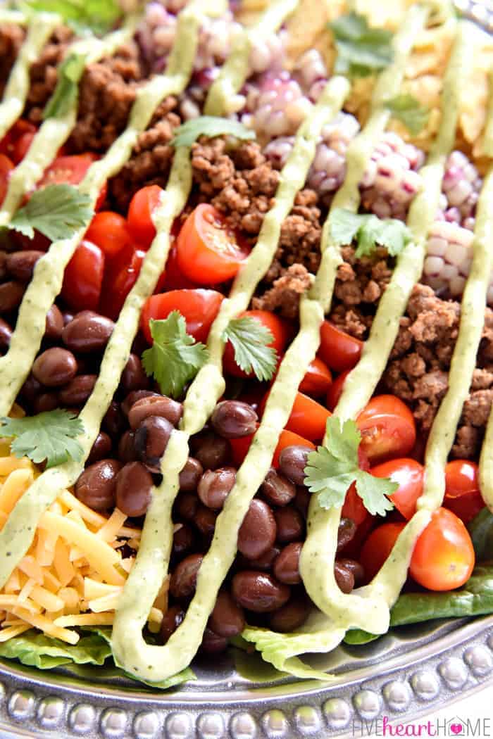 Ultimate Taco Salad On a Silver Platter with Drizzle of Avocado Ranch Dressing 