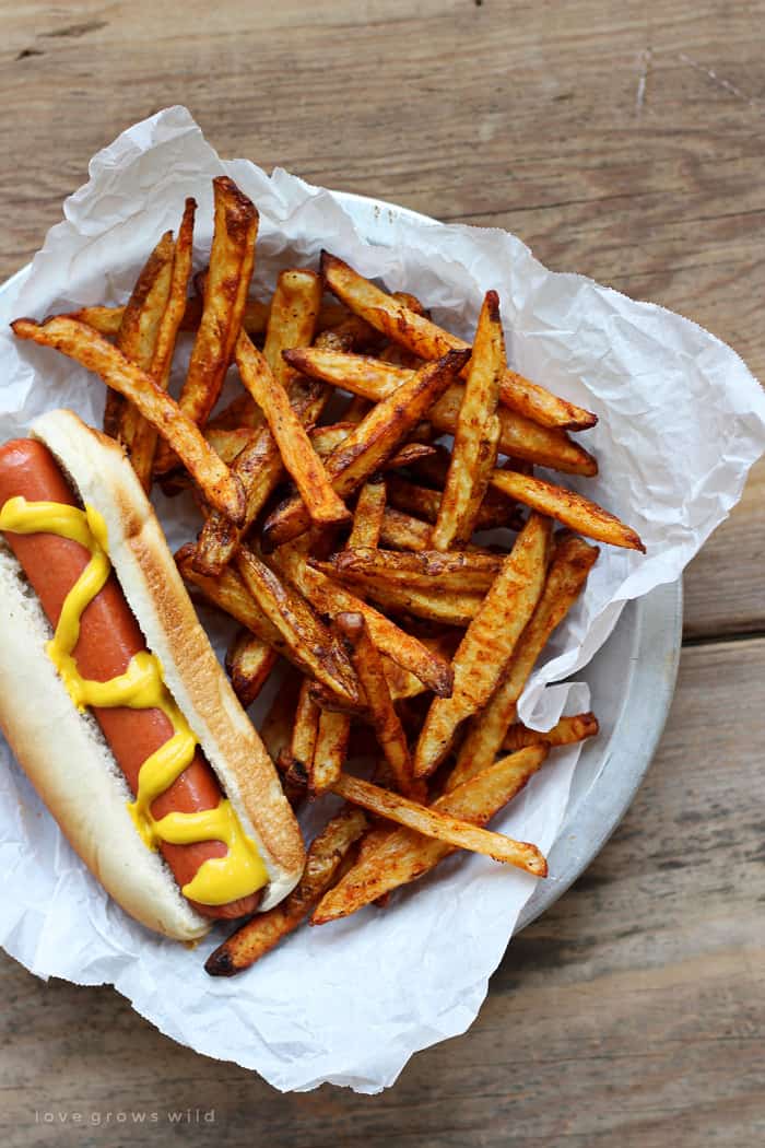 Baked Seasoned Fries in a basket with hot dog.