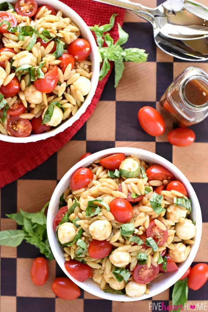 Two bowls on a cutting board with bottle of balsamic vinaigrette