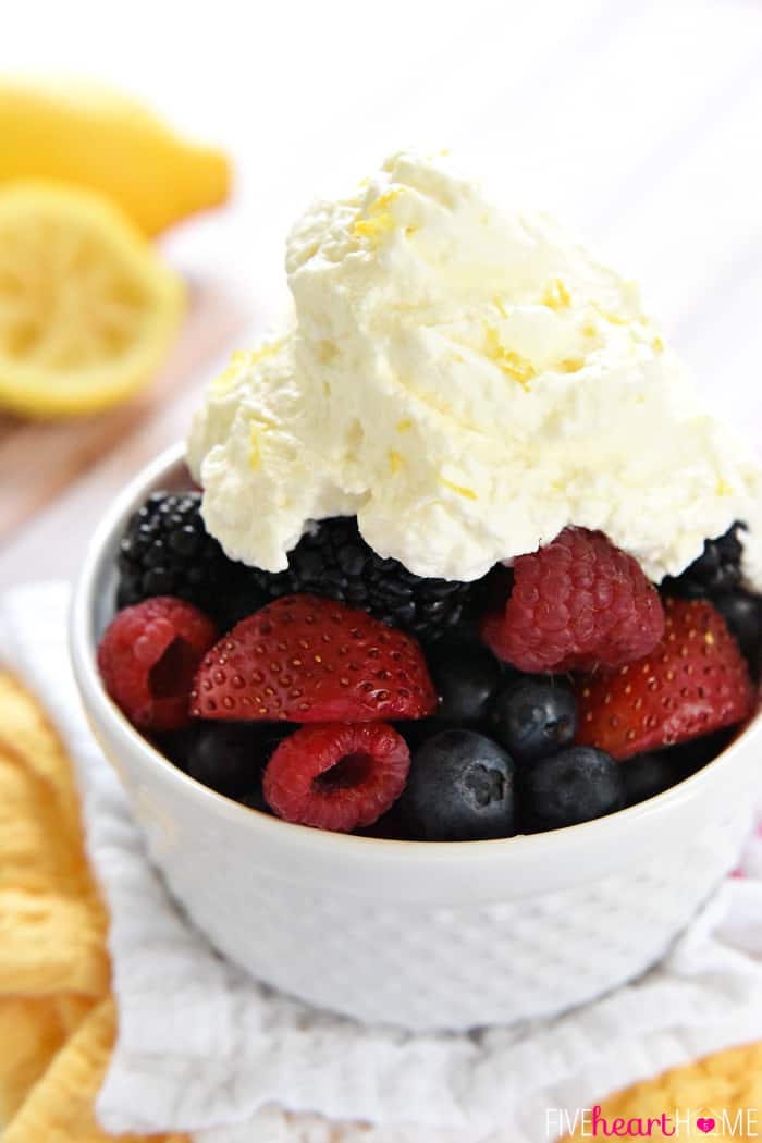 Lemon Whipped Cream dolloped over a bowl of fresh berries.