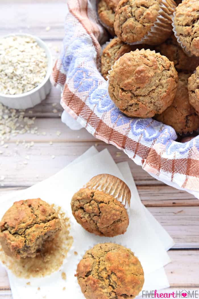 Oatmeal Muffins on table and in a lined basket.