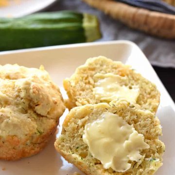 Savory Zucchini Muffins sliced open and spread with butter.