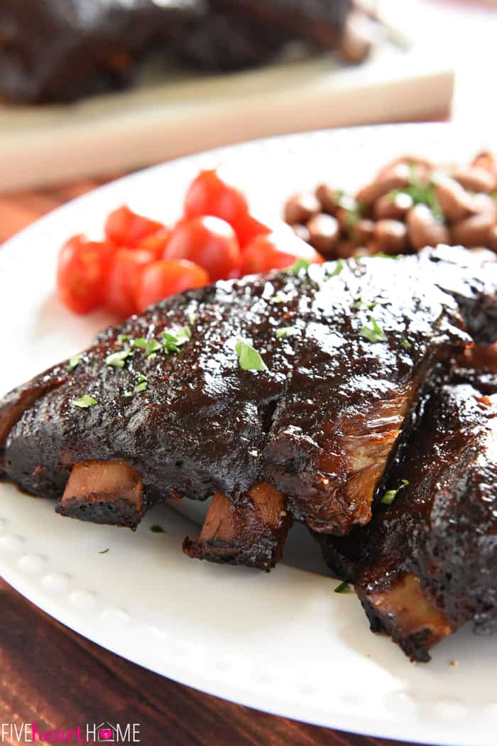 Close-up of slow cooker baby back ribs with sides on a white plate