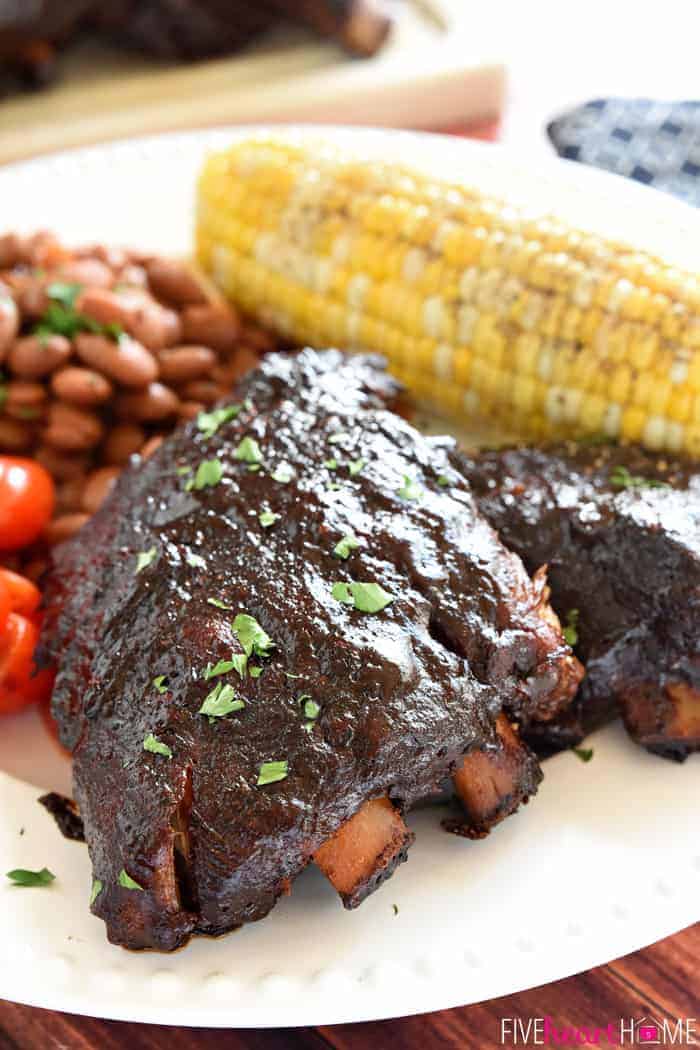 Served on a white plate with charro beans, cherry tomatoes and corn on the cob