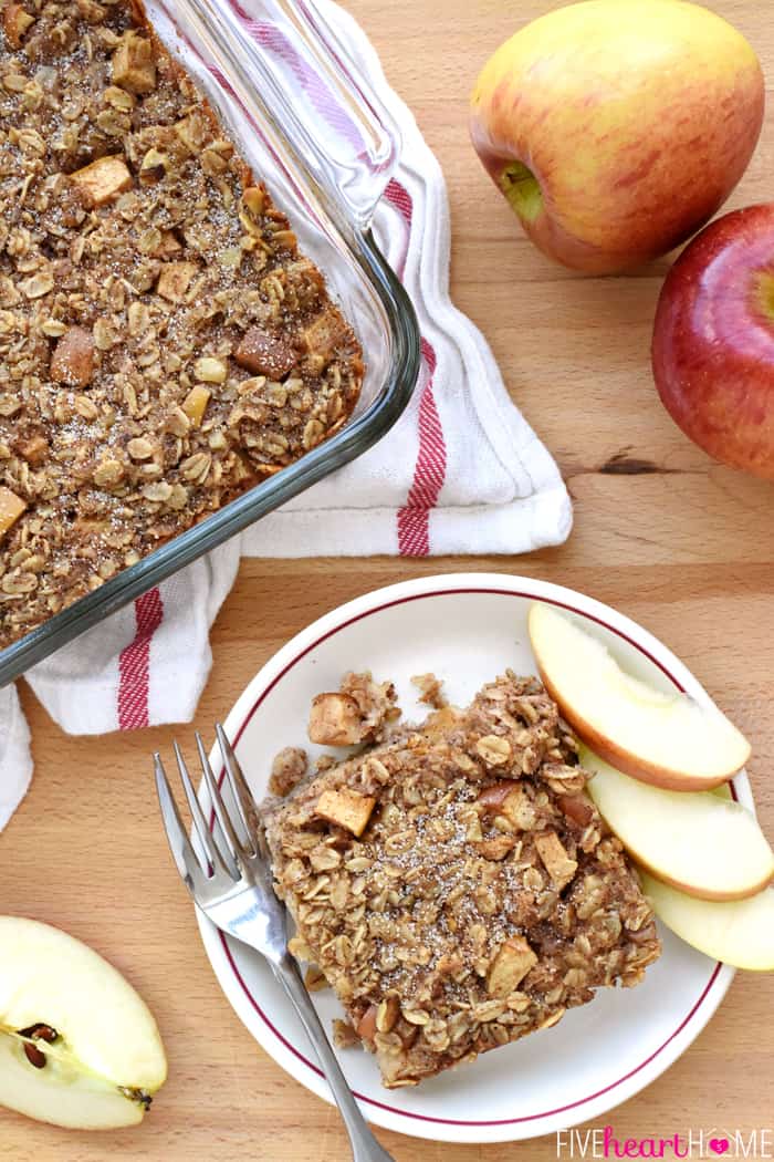 Aerial view of Baked Apple Oatmeal with apples on table, in serving dish and on plate.