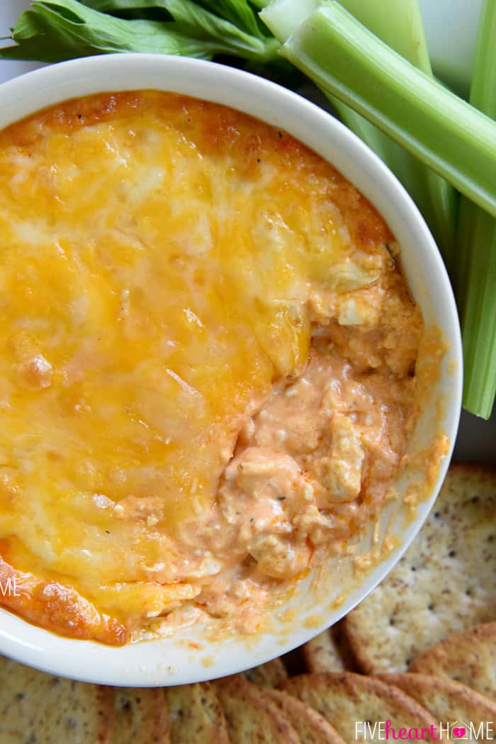 Buffalo Wing Dip (AKA, Buffalo Chicken Dip) ~ warm, creamy, and loaded with cheese, chicken, and wing sauce, this decadent appetizer is perfect for parties or ideal for game day tailgating! | FiveHeartHome.com Aerial view of Chicken Wing Dip with missing scoop.