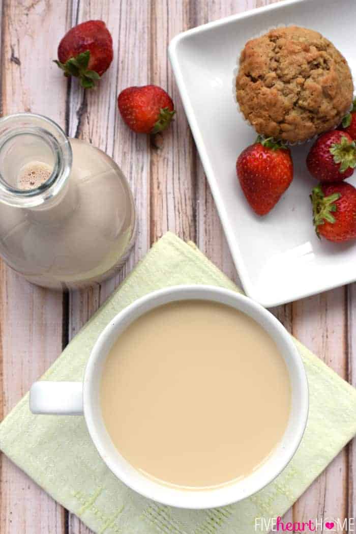 Aerial view of Chocolate Coffee Creamer, coffee cup, muffin, and strawberries.