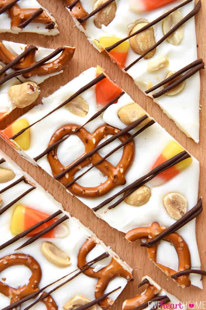 Aerial view of a piece of Halloween Bark made with white chocolate, candy corn, pretzels, and peanuts