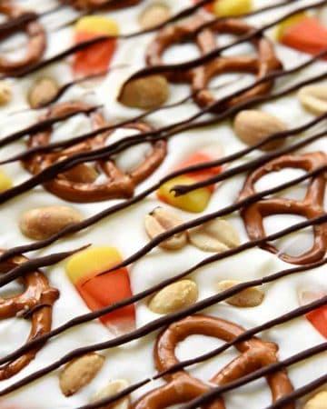 Halloween Candy Corn Bark ~ this sweet and salty homemade candy recipe features white chocolate studded with candy corn, pretzels, and peanuts, then drizzled with semisweet chocolate for a fun and tasty Halloween treat! | FiveHeartHome.com