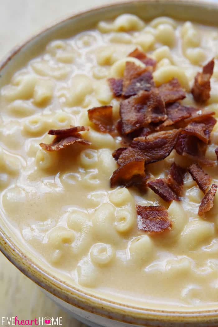 Close-up of Mac and Cheese Soup in bowl with bacon garnish.