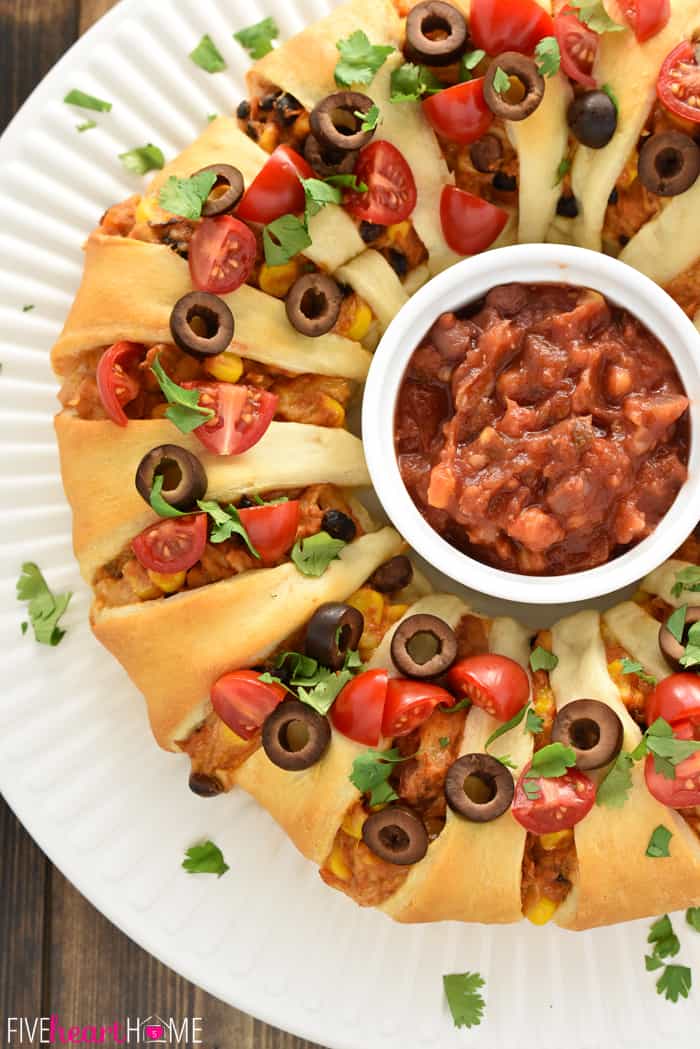 Chicken or Turkey Taco Crescent Ring ~ a delicious way to use up leftover chicken or holiday turkey...mixed with black beans, corn, and cream cheese, flavored with taco seasoning, and wrapped in light, flaky crescent roll dough for an easy yet impressive appetizer or dinner! | FiveHeartHome.com Aerial View of Chicken or Turkey Taco Crescent Ring on Round Platter with Dish of Salsa in the Middle