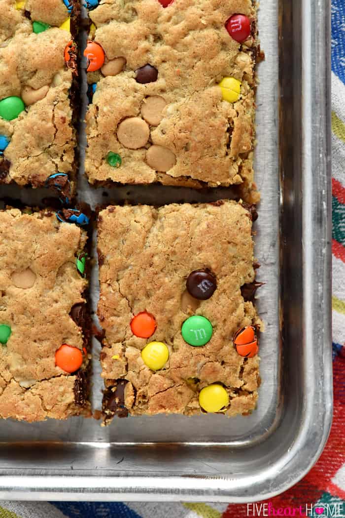 Monster Cookie Bars ~ loaded with chewy oats, decadent peanut butter, colorful M&Ms, chocolate chips, and peanut butter chips, this effortless batter whips up in no time! It's then spread in a large rimmed sheet pan for a BIG batch of bar cookies, perfect for sharing or serving at parties. Even better, you can customize these yummy cookies for various holidays by using seasonal M&Ms! | FiveHeartHome.com