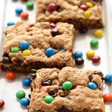 {One-Bowl, Big-Batch} Monster Cookie Bars ~ loaded with chewy oats, decadent peanut butter, colorful M&Ms, chocolate chips, and peanut butter chips, this effortless recipe whips up in no time! It is then spread in a large rimmed sheet pan to yield a big batch of bar cookies, perfect for sharing or serving at parties. Even better, you can customize these yummy bar cookies for various holidays by using seasonal M&Ms! | FiveHeartHome.com