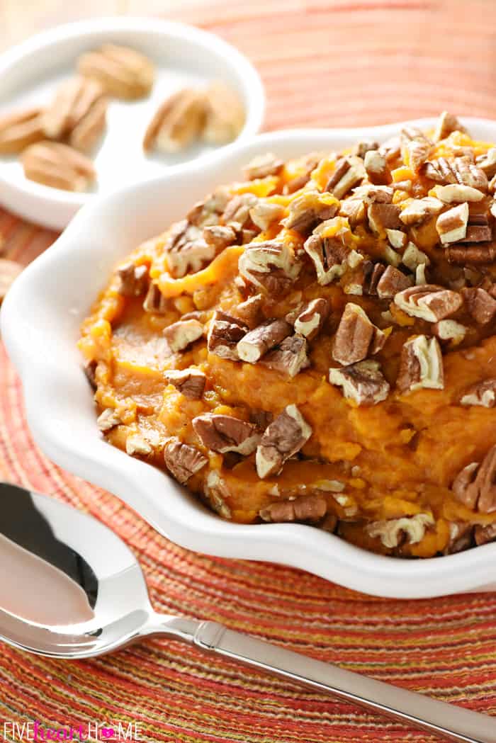 Crockpot Sweet Potatoes in serving dish topped with pecans.