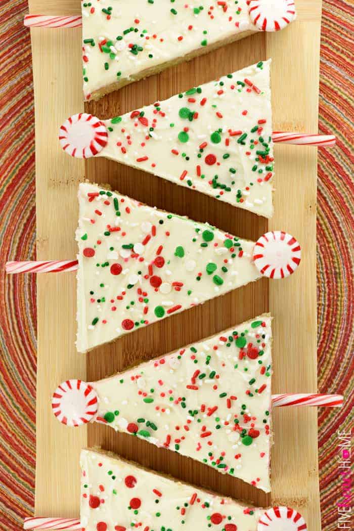 Aerial view of sheet cake Christmas trees lined up on wooden board.