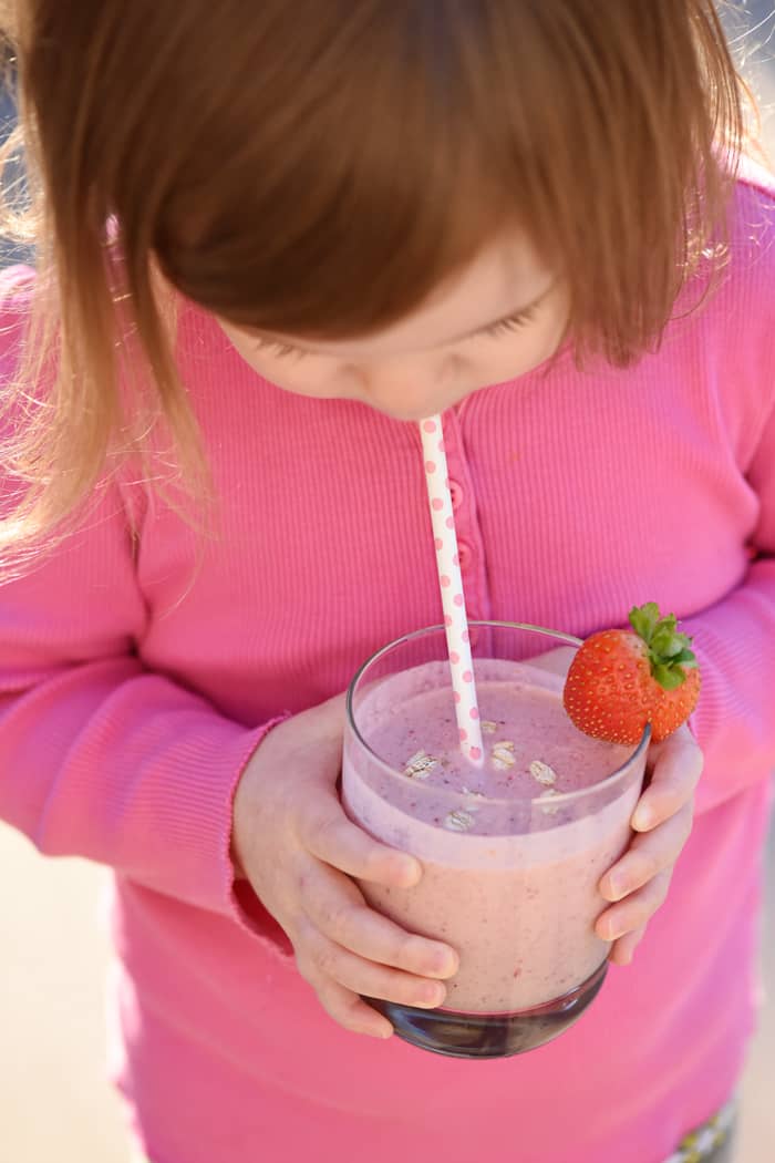 Toddler taking a sip of the smoothie 