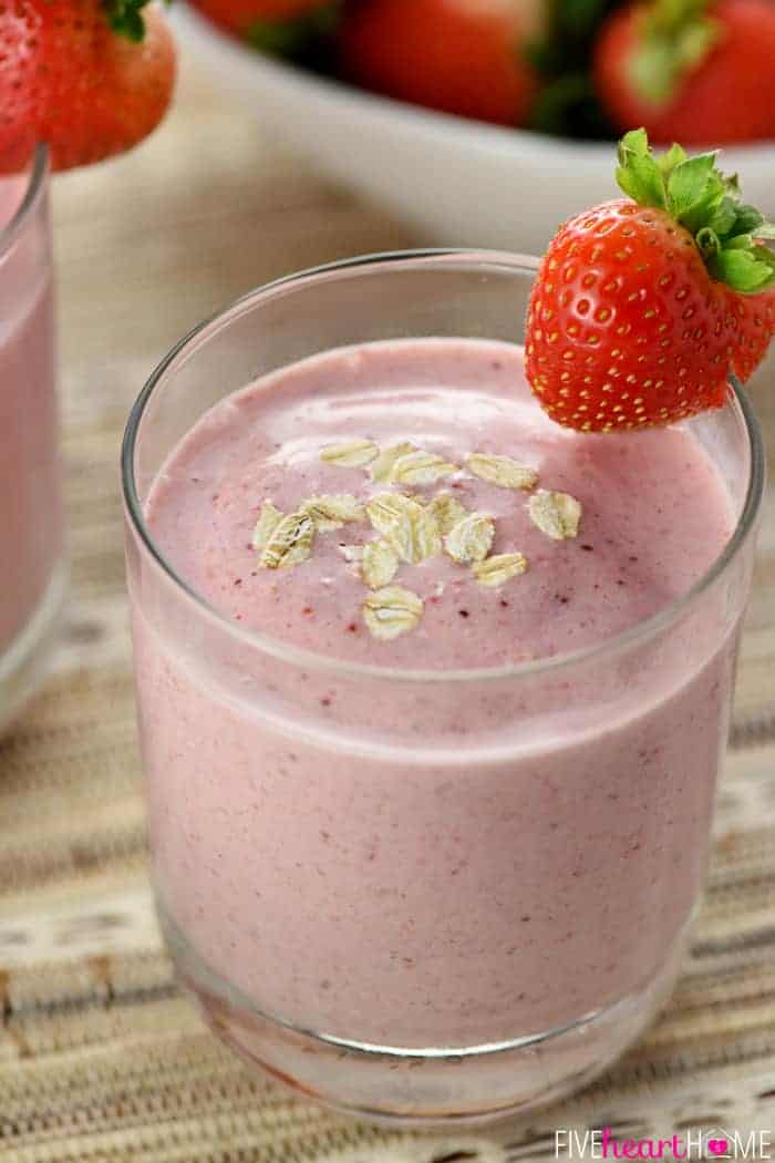 Strawberry Smoothie sprinkled with oats and garnished with a fresh whole strawberry