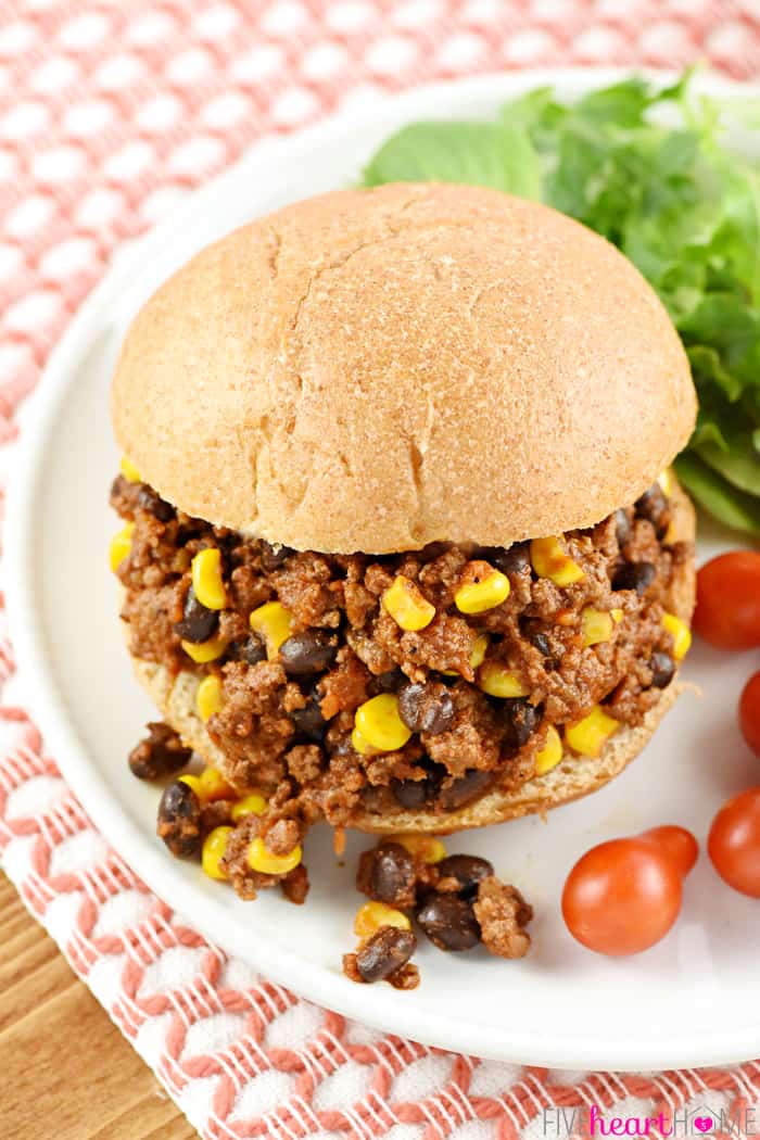 Aerial view of Taco Sloppy Joe on a plate with lettuce and tomatoes on the side
