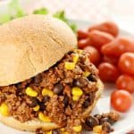 Taco Sloppy Joe sandwich on a plate with grape tomatoes on side