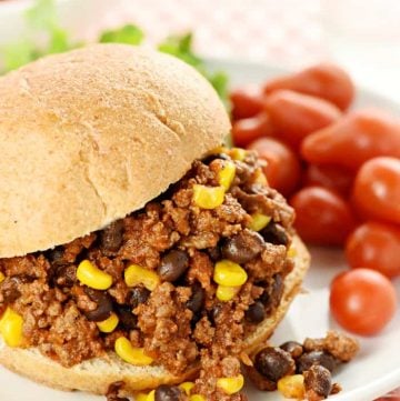 Taco Sloppy Joe sandwich on a plate with grape tomatoes on side