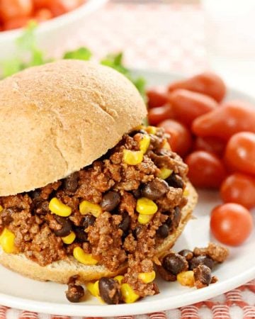 Taco Sloppy Joe sandwich on a plate with grape tomatoes on side