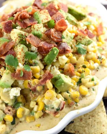 Ultimate Mexican Street Corn Dip ~ warm, creamy, and loaded with a mouthwatering combo of ingredients...corn, cotija cheese, avocado, bacon, jalapeños, cilantro, and chipotle chile powder for the perfect amount of smoky heat...ideal for Super Bowl, game day, or just about any party or get-together! | FiveHeartHome.com
