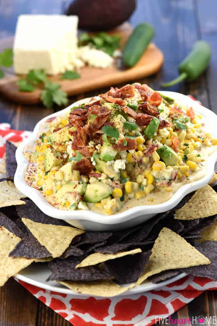 Warm, creamy, and loaded with a mouthwatering combo of ingredients...corn, cotija cheese, avocado, bacon, jalapeños, cilantro, and chipotle chile powder for the perfect amount of smoky heat...ideal for Super Bowl, game day, or just about any party or get-together! | FiveHeartHome.com
