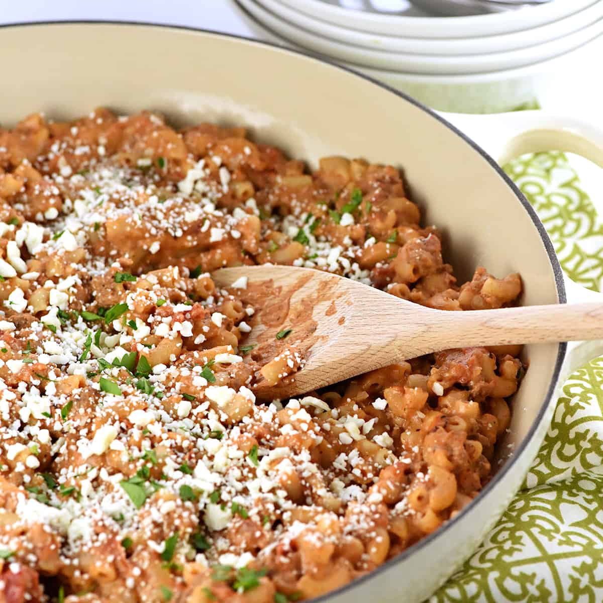 Pastitsio Recipe in a skillet with a wooden spoon.