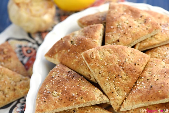 Roasted Garlic Hummus ~ mellow roasted garlic is blended with chickpeas, tahini, olive oil, and lemon juice for a fresh, creamy hummus that's delicious with homemade pita chips or crunchy veggie dippers! | FiveHeartHome.com Platter of homemade pita chips.