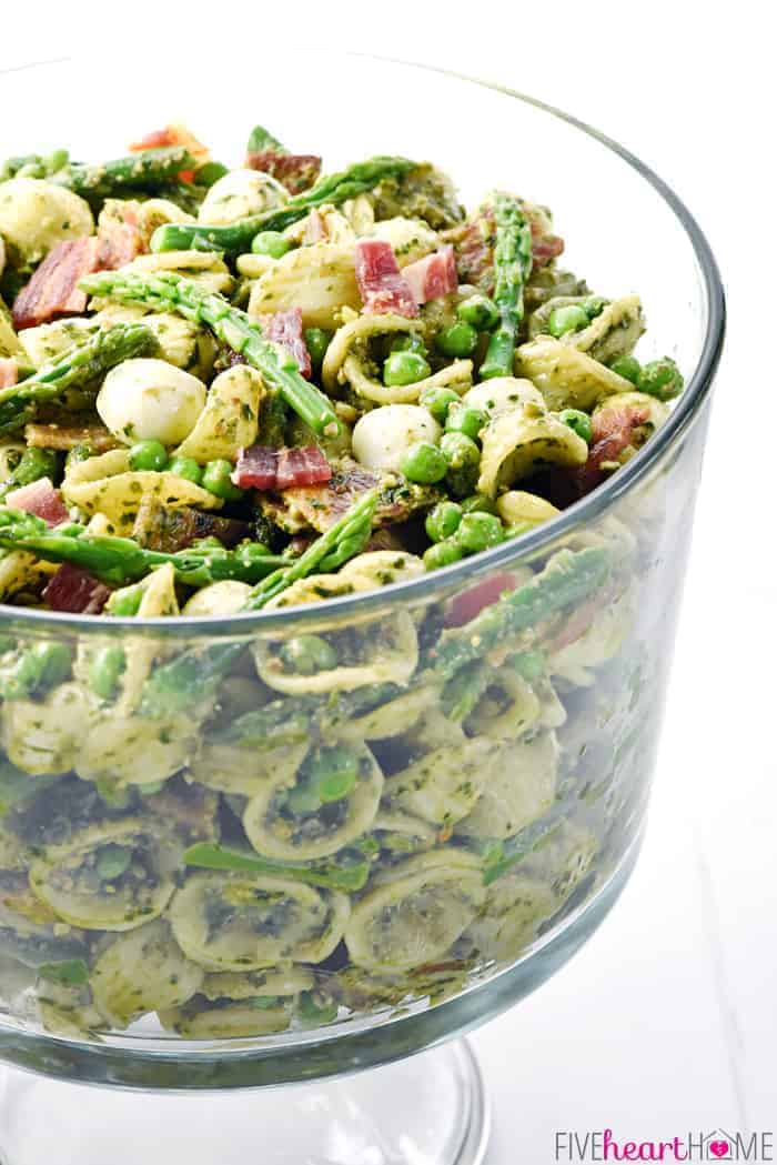 Side view of Pesto Pasta Salad in glass pedestal bowl.