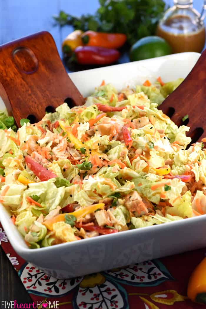 Thai Chicken Chopped Salad with Peanut Dressing ~ exploding with the contrasting flavors and textures of crunchy Napa cabbage, juicy chicken, colorful peppers, sweet carrots, salty peanuts, and fresh cilantro! | FiveHeartHome.com In Serving Bowl with Wooden Salad Forks to Toss