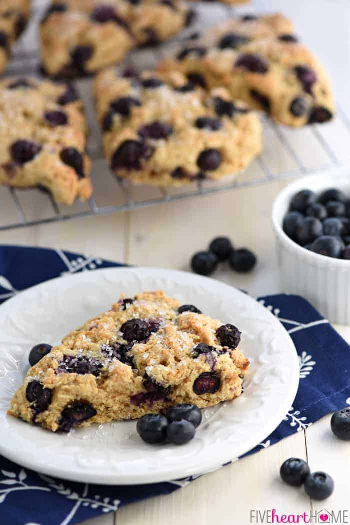 Whole Wheat Scones on cooling rack and ready to serve on white plate with blueberries.