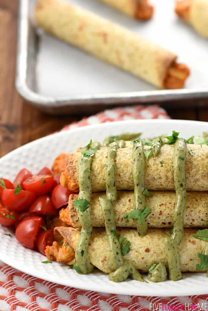 Baked Chicken Taquitos with Avocado Cilantro Dipping Sauce on White Platter 