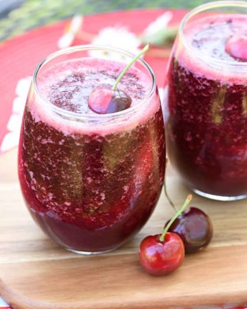 Two glasses of Wine Slushies with cherry garnish.